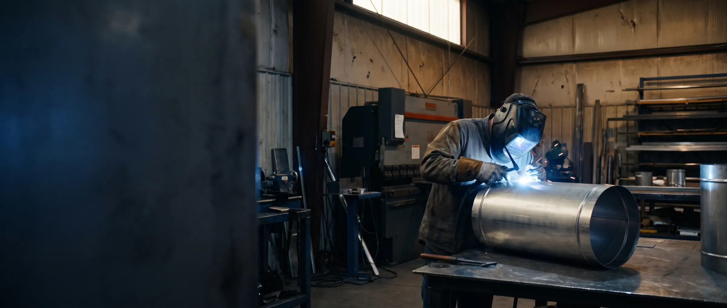 Fabricator welding a stainless steel duct in the workshop